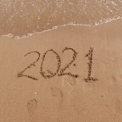 inscription on the sand 2021. symbol 2021 on the coast, overlooking the sea. Summer holidays in the new season.