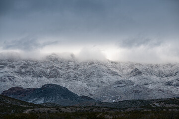 Fototapeta na wymiar Low lying clouds and snow cover the Franklin Mountains in El Paso Texas. 