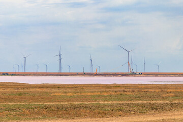 Wind turbines on a shore of the pink salty Syvash lake in Kherson region, Ukraine. Renewable energy