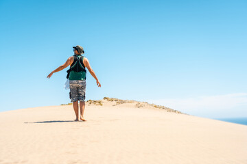 A young man walking with his son on the sand dune on Monsul beach in the Cabo de Gata Natural Park, municipality of San Jose, Almeria. Spain