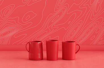 Single red color 2 coffee mugs and a water glass side by side on monochrome red color kitchen counter top with wall, close up front view, 3d rendering, no people