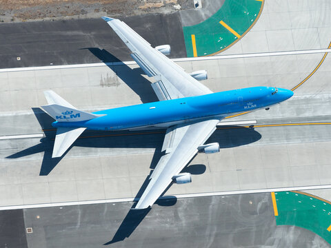 Aerial view of Royal Dutch Airlines Boeing 747 departure from LAX airport. KLM B747 aircraft taking off. Jumbo airplane model being retired by KLM.