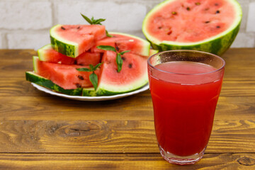 Glass of fresh watermelon juice on a wooden table