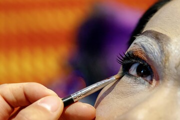 Drag performer applying eye makeup