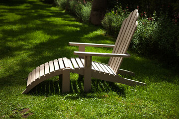 wooden lounger lying on the grass. A bed on green juicy grass. Rest and relaxation in nature.