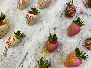 Strawberries covered with different chocolate in box on wooden background