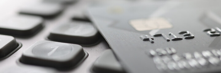 Bank plastic card lying on calculator closeup