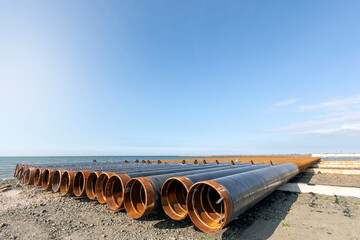 View of the steel pipe piles to build pier in the sea. Offshore piles have been commonly used as a...