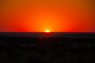 beautiful sunset with intense red and cloudless sky in Etosha National Park, panoramic view from the top of the view point in Namutoni Camp.