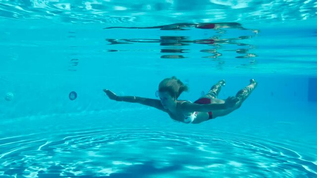 Sweet young lady swimming underwater 