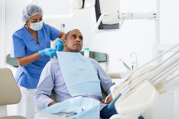 Obraz premium Dental assistant prepares the patient for surgery