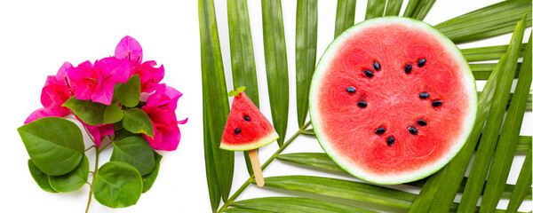 Watermelon slices on tropical palm leaves and red bougainvillea flowers on white