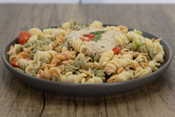 Plate of appetizing pasta salad is a perfect meal for a quick lunch break at work.