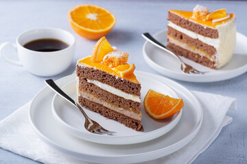 Cake, orange and coffee on a light wooden table..