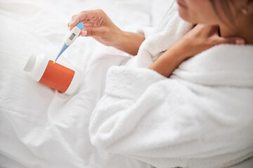 Beautiful female with medicine pills resting in bedroom