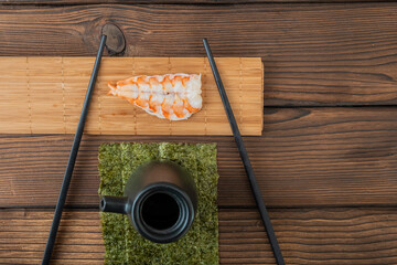 open shrimp to cook sushi with chopsticks in wood table