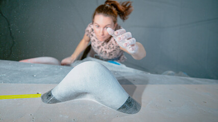 CLOSE UP: Detailed shot of a chalk covered hold as climber tops a boulder.