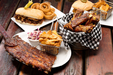 Barbecue restaurant food selection.  Barbecued pork ribs, beef ribs, pulled pork sandwich, and beef dip with home cut french fries.