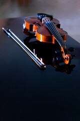 violin and bow on top of the piano