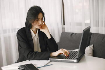 Girl in a business suit works in a loptop