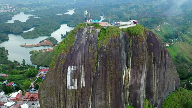 Aerial Backward Shot Of Top View Of El Penon Rock, Drone Flying Over Popular Landscape During Day - Guatape, Colombia