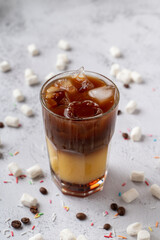 Modern coffee shop seasonal drink: iced coffee with orange juice and caramel syrup, bumble coffee
