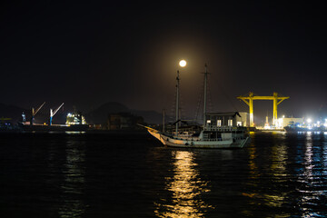 Fototapeta na wymiar Entrance to the port of Santos with the full moon rising in the background