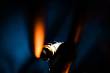 Macro Closeup of Back of Metal Quarter Inch Connector on Audio Cable on Front of Teal Background with Orange Lighting