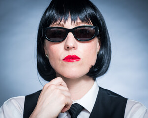 Cheeky Young Citizen with Black Hair, Dark Suit, Red Lips and Mysterious Shades.