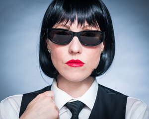 Cheeky Young Citizen with Black Hair, Dark Suit, Red Lips and Mysterious Shades.
