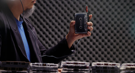 Man hold Vintage Cassette Tape Player and wired headphone