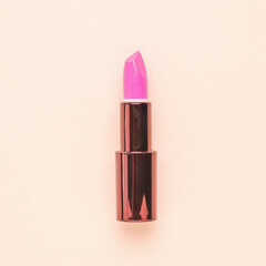 Beautiful pink lipstick on beige background. Flat lay.