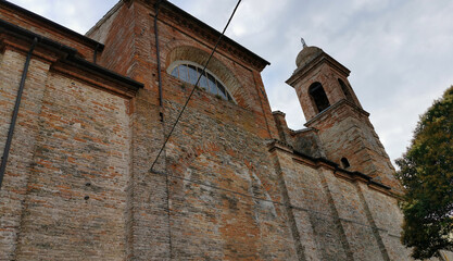 Fototapeta na wymiar Torre campanaria e mura di una antica chiesa in un borgo medioevale