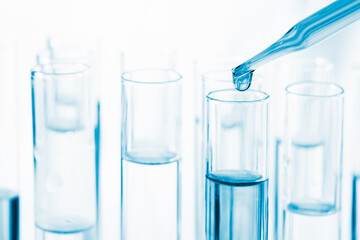 close up view of scientist dripping liquid into a test tube, laboratory experiments research scientific concept.