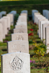 Gravestones honouring the fallen soldiers of WWII are neatly lined up in the Bayeux War Cemetery in Normandy, France.