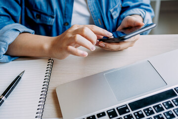 close up view of hands women using smartphone while working at home, lifestyle female freelancer office, chatting online via application mobile phone.