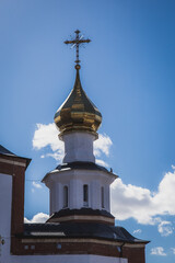 Fototapeta na wymiar golden domes of the orthodox church with beautiful crosses at the top against the blue sky
