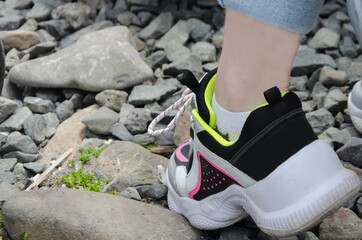 women's feet walking on rocks hiking, rock walking, selective focus
