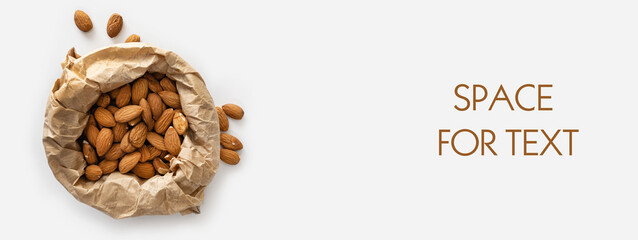 banner, almonds in craft paper, keto food, on a white background, top view, empty space for text