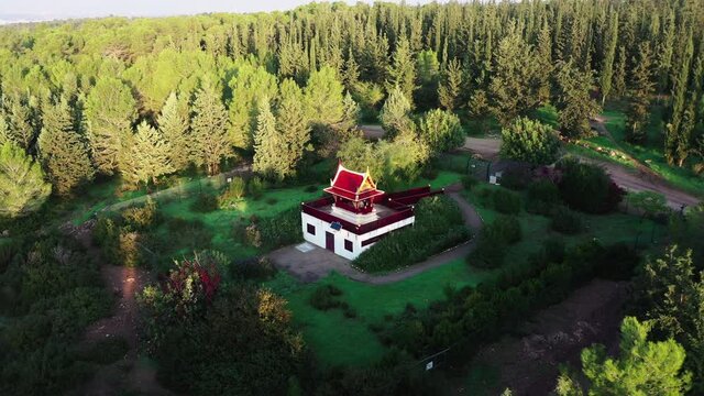 Aerial Panning Shot Of Pagoda Amidst Forest On Sunny Day, Drone Flying Over Famous Landscape - Ben Shemen, Israel