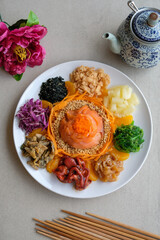 Delicious and colorful display of Chinese prosperity cuisine / Yee Sang aka Prosperity Toss / Carrot strips, purple cabbage, fresh seaweeds, jelly fish, deep fried fish skin, ground peanuts, fritters