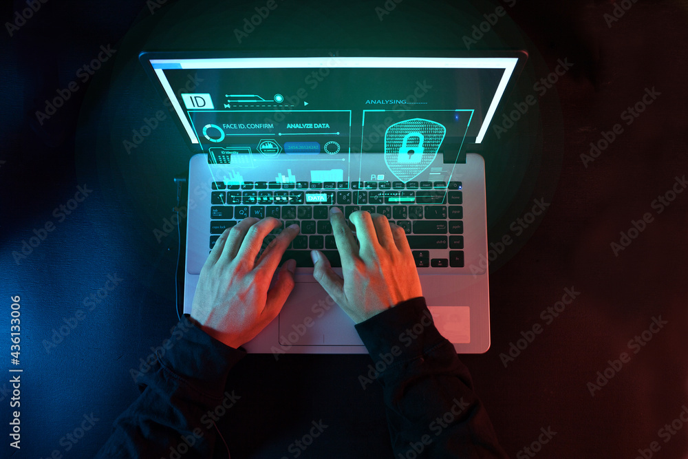 Poster hacker in the hood working with futuristic laptop