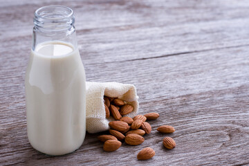 Almond milk on wooden table.