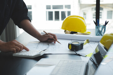 Architects or engineers working construction and drawing construction plans, printing, writing on-site construction sites. Home design concept