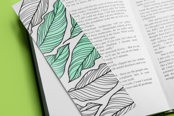Cute bookmark with book on color background, closeup