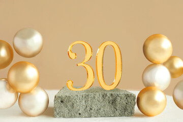 Number 30 on a concrete podium and volumetric golden balls on a beige background. Copy space..