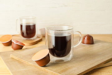 Cup of coffee with capsule on table