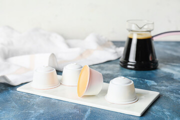 Board with coffee capsules on table
