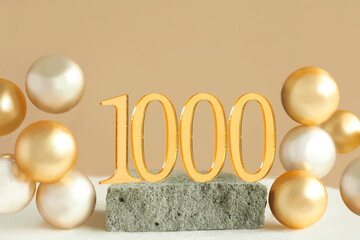 Number 1000 on a concrete podium and volumetric golden balls on a beige background. Copy space.. - obrazy, fototapety, plakaty