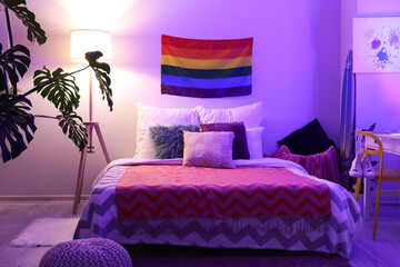 Flag of LGBT hanging on wall in interior of bedroom at night